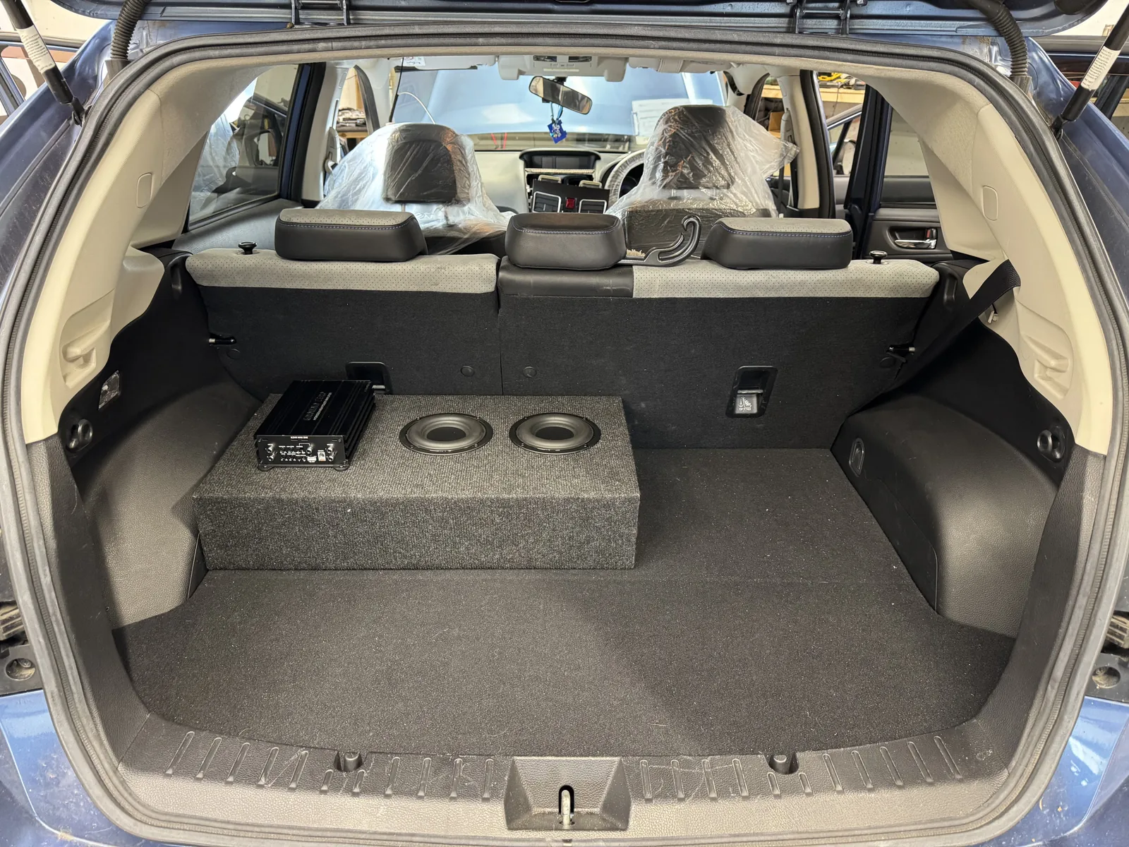 Compact dual five inch subwoofer enclosure and amplifier in Subaru Impreza boot
