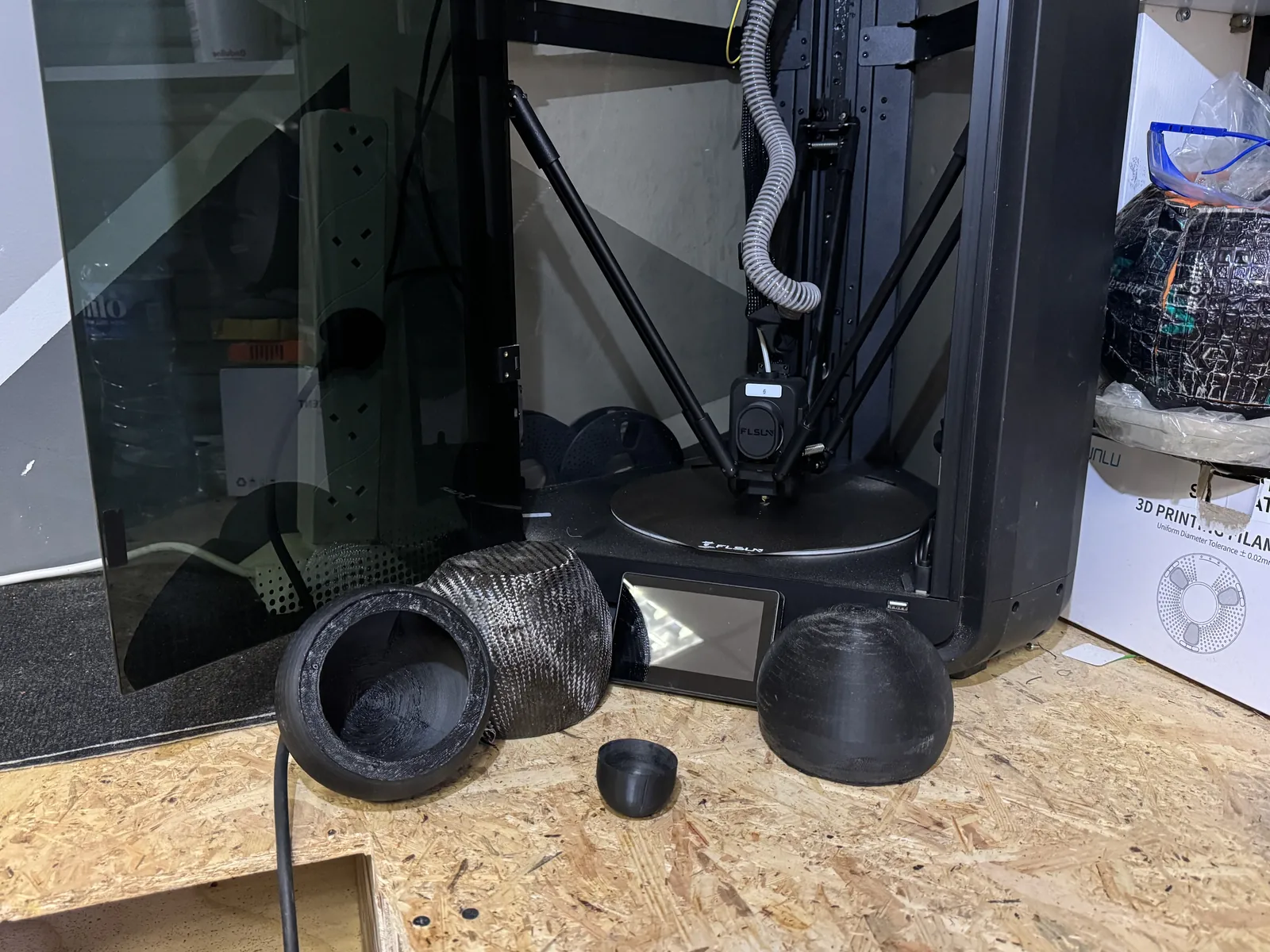 Custom fabricated 3D printed car speaker enclosure components on workshop bench